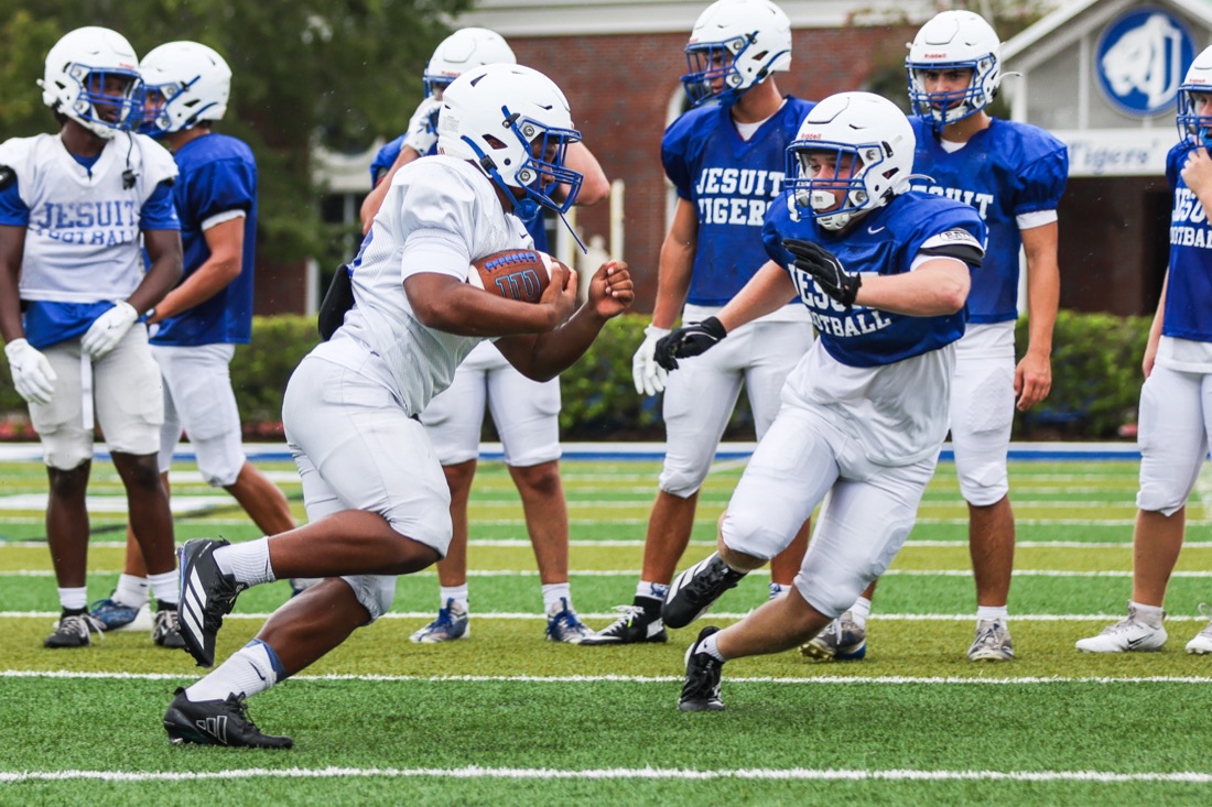 Jesuit football players running live reps at practice
